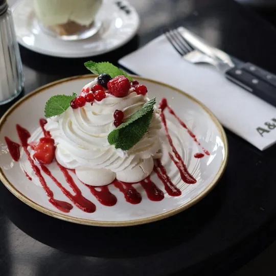 Pavlova nappée de coulis de fruits rouges et de baies fraîches
