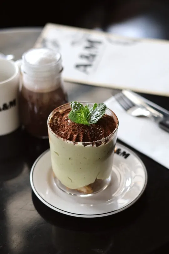 Tiramisu à la pistache saupoudré de cacao, feuille de menthe